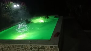 Una piscina con iluminación verde por la noche.
