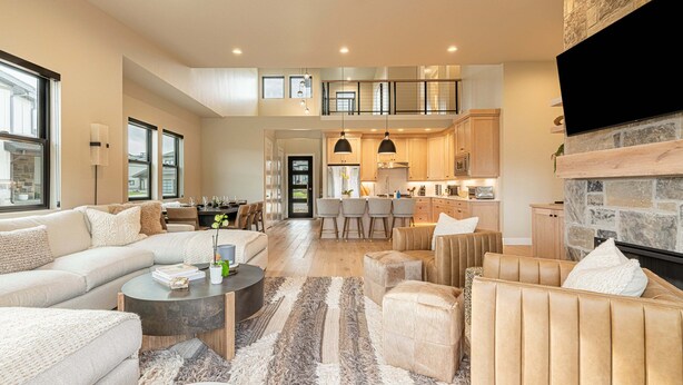 A spacious living area with a sofa, armchairs, a coffee table, and a fireplace. - New and Fun in Deer Valley East Village - Free Mountain Mover on demand ski shuttle (Heber City)