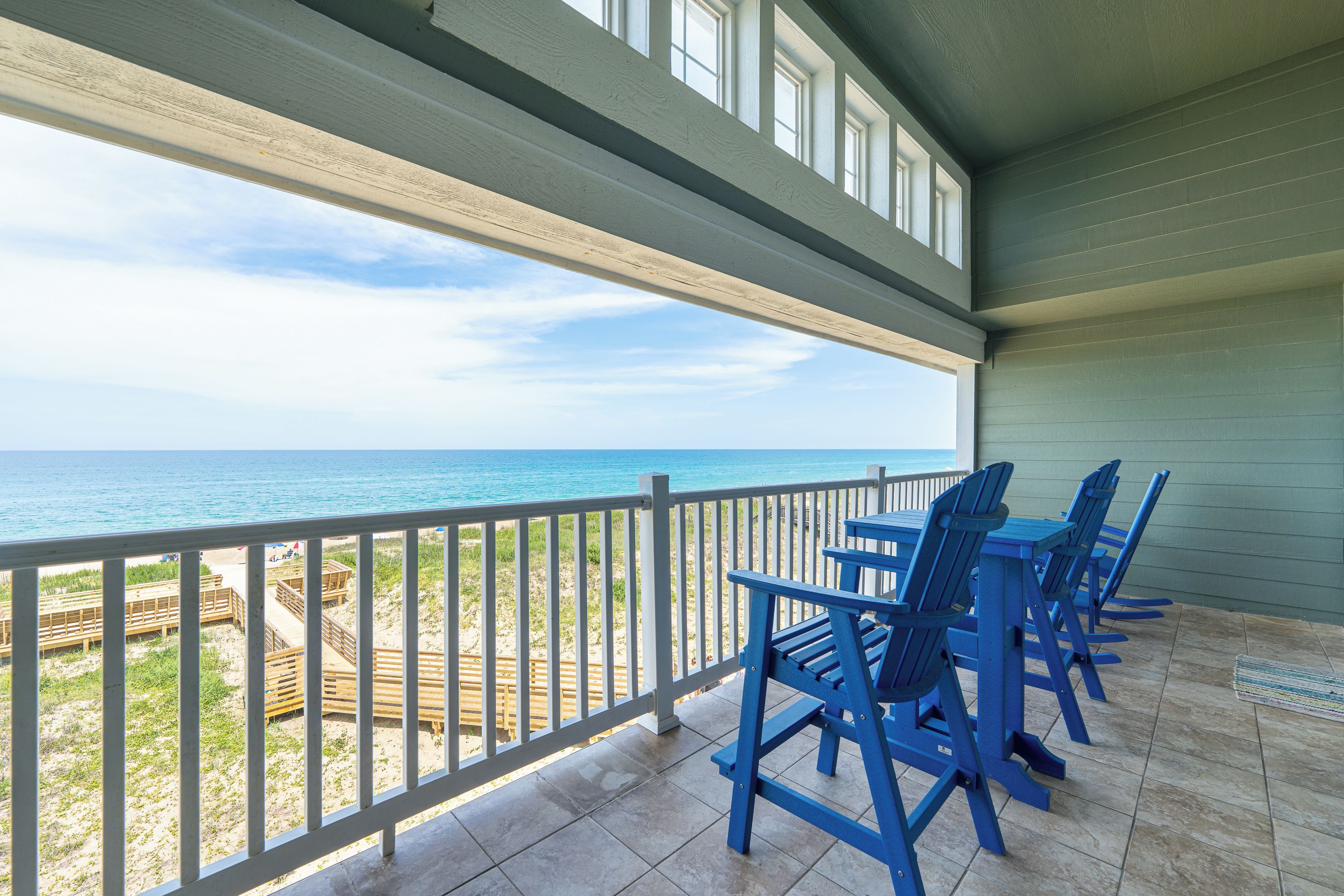 A covered outdoor area with a view of the beach and ocean.