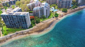 A coastal hotel with multiple high-rise buildings, a sandy beach, and a clear blue ocean. - Valle Isle (Lahaina)