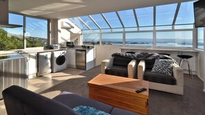Eine moderne Küche mit Blick auf die Stadt, ein Sofa und ein Holztisch.