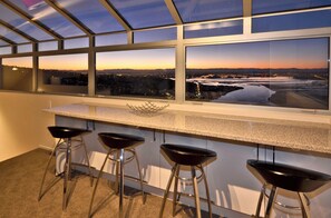 Una cucina moderna con un'ampia finestra che si affaccia su un panorama cittadino al tramonto.
