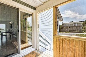 Sliding glass door leads to a covered outdoor area with a wooden deck.