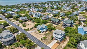 An aerial view of a coastal residential area with houses, a beach, and a road. - Duck, Duck, Goose | 650 ft to the beach | Hot Tub (Duck)