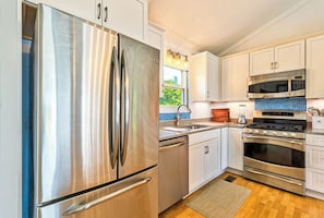 Enjoy cooking in this well-equipped kitchen with a refrigerator, dishwasher, microwave, and oven.