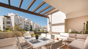 A modern outdoor patio with a white table and chairs, a sofa, and a pergola. - Colinas - Tahona 3.2 PENTHOUSE JACUZZI & POOL VIEW (Arona)