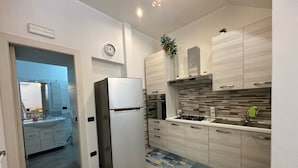 Eine moderne Küche mit integriertem Kühlschrank, einem Gasherd und hellen Holzschränken.