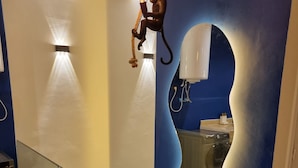 A modern interior with a glass railing, a unique wall design, and a visible washing machine.