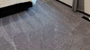 Une chambre à coucher comprenant un lit, une table de chevet, une lampe, une fenêtre avec des rideaux et un panneau fixé au mur.