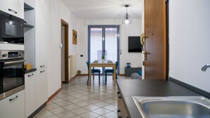 A modern kitchen with a dining area, a built-in oven, and a large window. - Discover the pleasure of living in the heart of Bellano, kissed by the beauty of Lake Como.Its central location allows you to immerse yourself in the vibrant life of Bellano, with its characteristic shops, delicious restaurants and authentic atmosphere.  (Bellano)