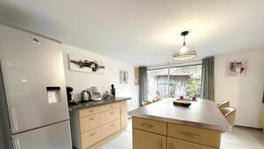 Eine moderne Küche mit Kühlschrank, Herd und Essbereich.
