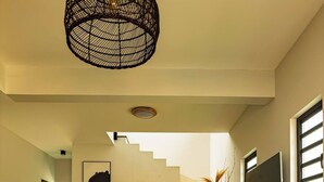 Ein geräumiges Wohnzimmer mit einem Holzesstisch, einer Couch und einer Treppe, die zu einer weiteren Ebene führt.