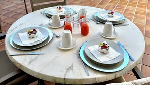 A round table set for a meal with plates, cutlery, and a glass of juice. - Starbal (Es Castell)