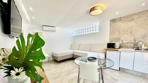 A modern kitchen with a glass dining table, white appliances, and a large window. - Starbal (Es Castell)