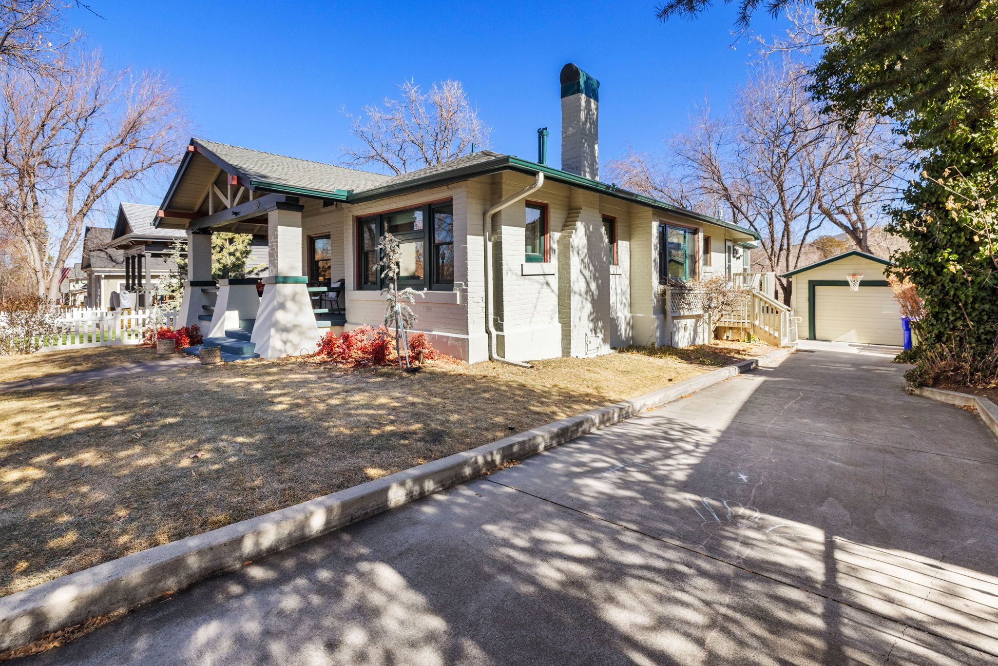 A two-story house with a chimney, a front porch, and a garage.