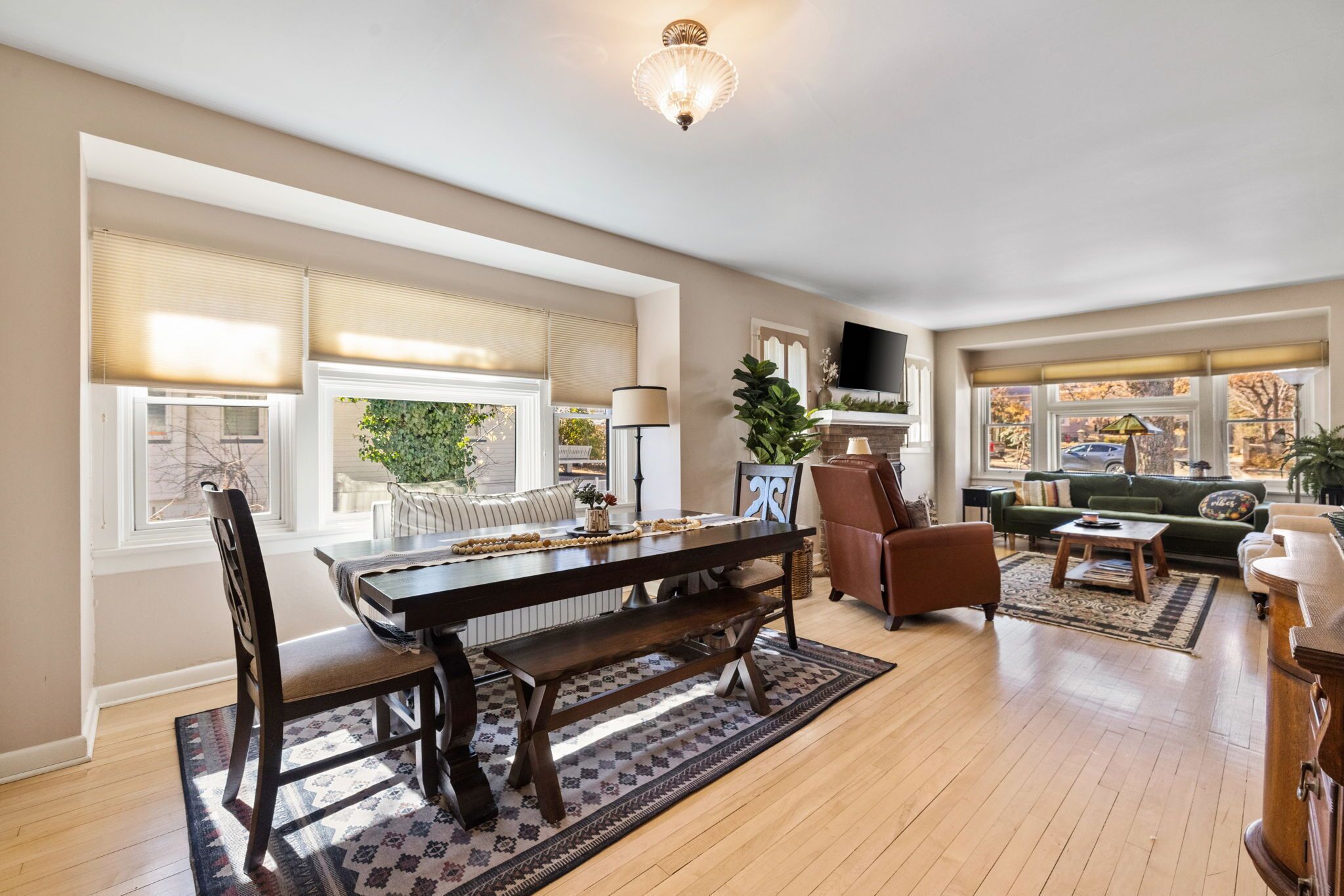 A spacious living room with a large wooden dining table, comfortable seating, and a fireplace.