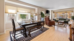A spacious living room with a large wooden dining table, comfortable seating, and a fireplace. - The American Dream: Historic S Mt Vernon Craftsman (Prescott)