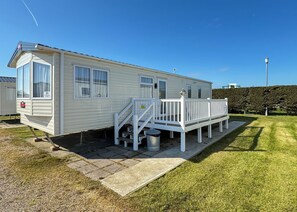 Une maison mobile dotée d’une terrasse, d’un escalier et d’un panneau indiquant le numéro d’unité 25.