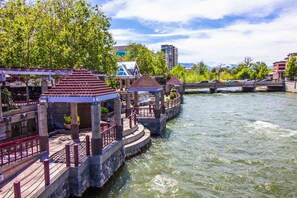 A riverside walkway with stone bridges and pavilions.