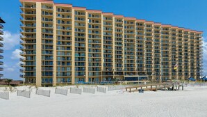 A high-rise hotel with multiple balconies and a beach view. - Beachfront 1BR @ Phoenix V • Sleeps 4 • Pools, Hot Tub & Pirate Splash Pad (Orange Beach)