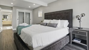 A modern bedroom with a large bed, bedside tables, and a nightstand. - Canandaigua Lakefront | Dock | Fire Pit | Kayaks (Rushville)