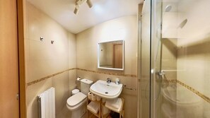 A bathroom with a toilet, sink, and glass-enclosed shower. - Mimosa 7 - tucasaenlospirineos (Escarrilla)
