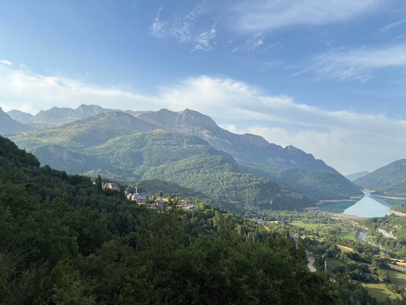 A mountainous landscape with a lake and a town nestled in the valley.