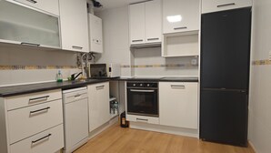 A kitchen with white cabinets, a black refrigerator, a microwave, and a dishwasher.