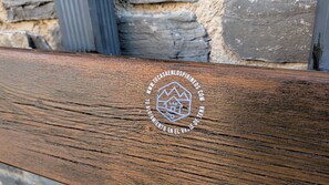 Un banco de madera con un logotipo y texto que indica una conexión a un sitio web de bienes raíces.