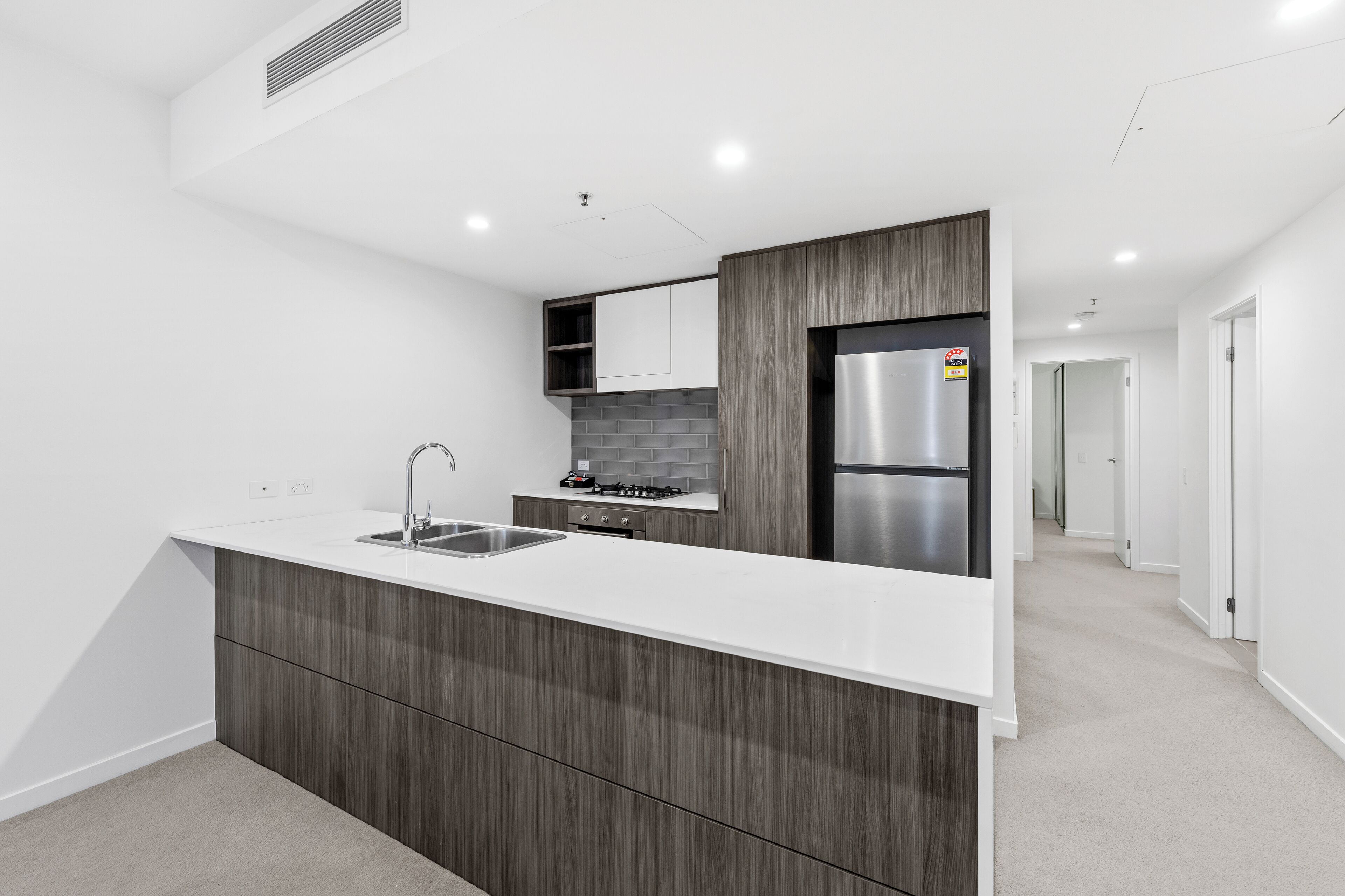 A modern kitchen with a large island, built-in appliances, and a minimalist design.
