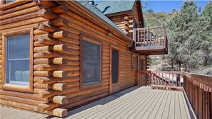 A log cabin with a deck and a balcony.