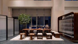 A modern interior with a dining area, large windows, and a large TV screen. - Suisse Place Olympic Sports Center Nanjing (Nanjing)