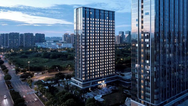 A high-rise building with a modern glass facade, surrounded by greenery and a busy road. - Suisse Place Olympic Sports Center Nanjing (Nanjing)