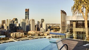 Ein Infinity-Pool auf dem Dach mit Blick auf die Stadtlandschaft.