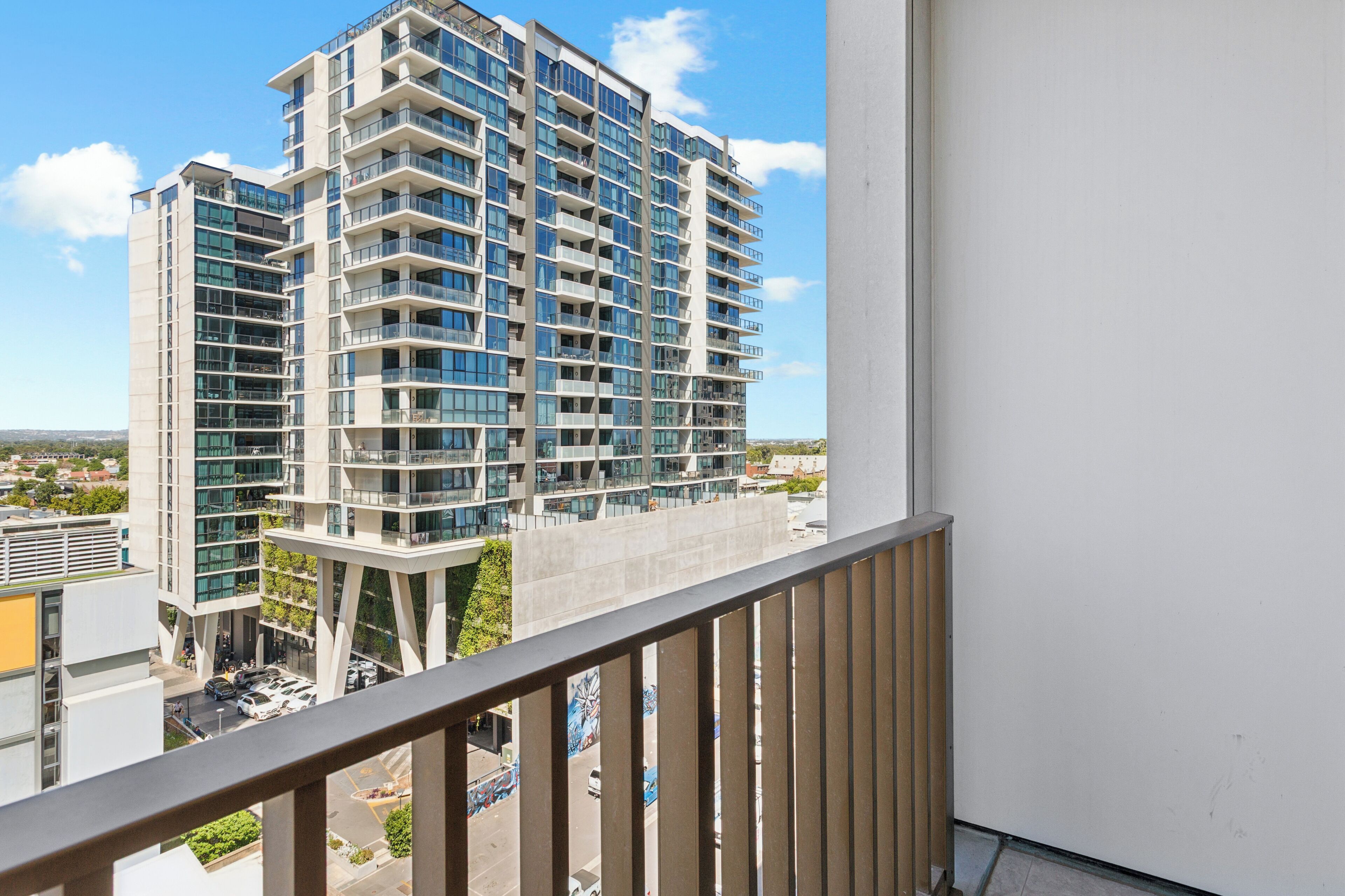 A high-rise building with multiple balconies and a view of the surrounding cityscape.