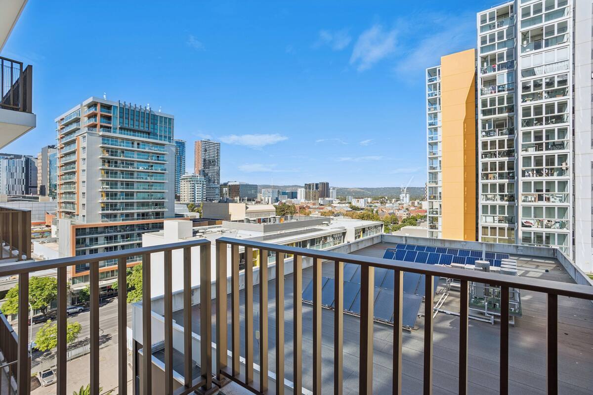 A high-rise building with a modern architectural design, featuring multiple balconies and large windows.