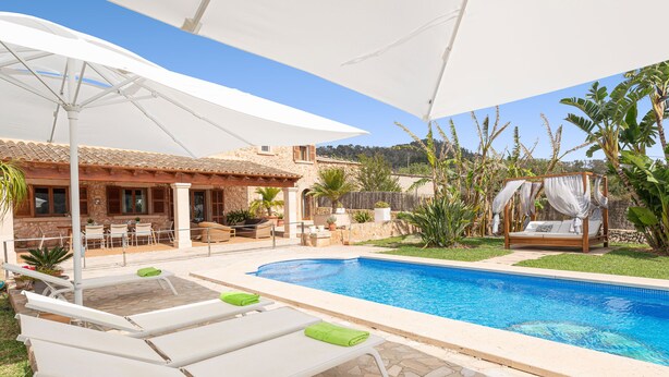 A poolside area with lounge chairs, a covered seating area, and a view of the surrounding landscape. - CAN LLIGANYA - Rustic villa with private pool and free wifi (Felanitx)