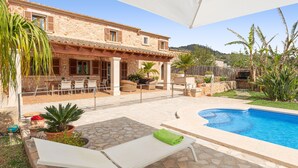 A stone building with a pool, outdoor seating, and potted plants. - CAN LLIGANYA - Rustic villa with private pool and free wifi (Felanitx)