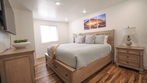 A bedroom with a bed, bedside tables, a TV, and a window. - Entire House Between Zion & Bryce w/ Hot Tub! (Orderville)