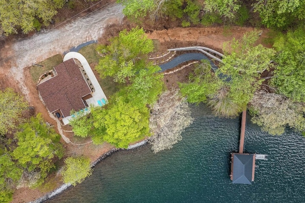 Vue aérienne d’une propriété comprenant une maison, un quai et un petit plan d’eau.