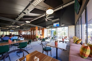 Enjoy meals in a spacious dining area with tables and benches, offering views of the outdoors.