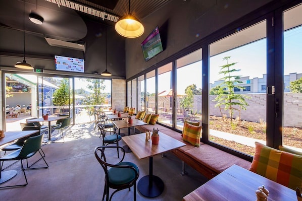 Guests can enjoy meals at a dining table with a television for entertainment.