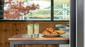 A table with two glasses of iced drinks, garnished with lemon slices and mint, and a plate of croissants. - Chaesonghwa Glamping in Yeongcheon (Yeongcheon)
