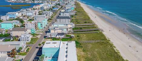 A coastal town with a long beachfront, rows of houses, and a clear view of the ocean.