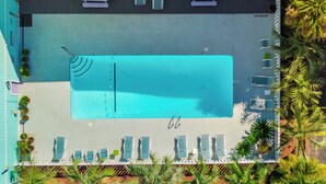 An aerial view of a pool area with lounge chairs and a pool. - A Place At The Beach #1D by Carolina Retreats (Carolina Beach)