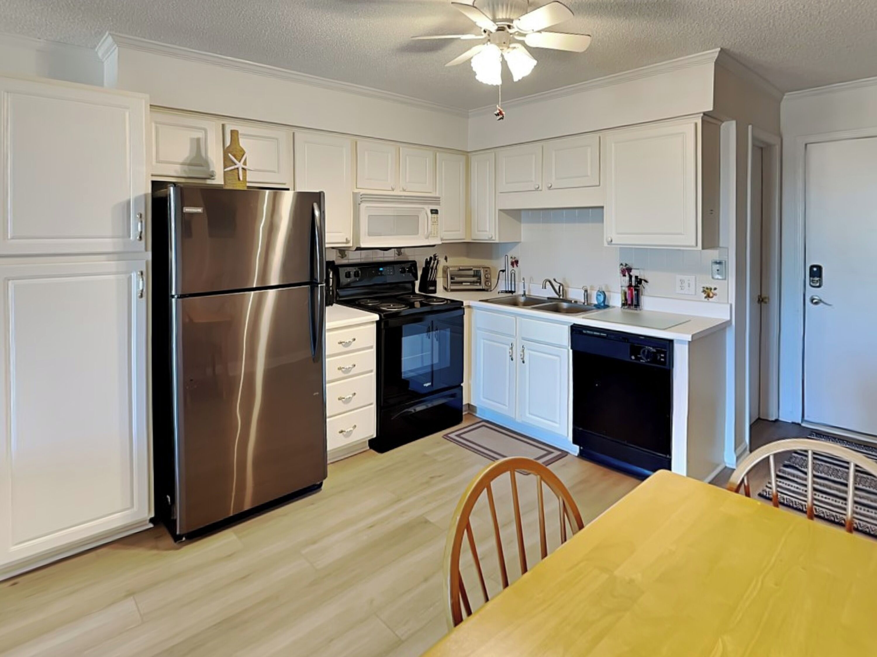 A modern kitchen with white cabinets, stainless steel appliances, a microwave, and a dishwasher.