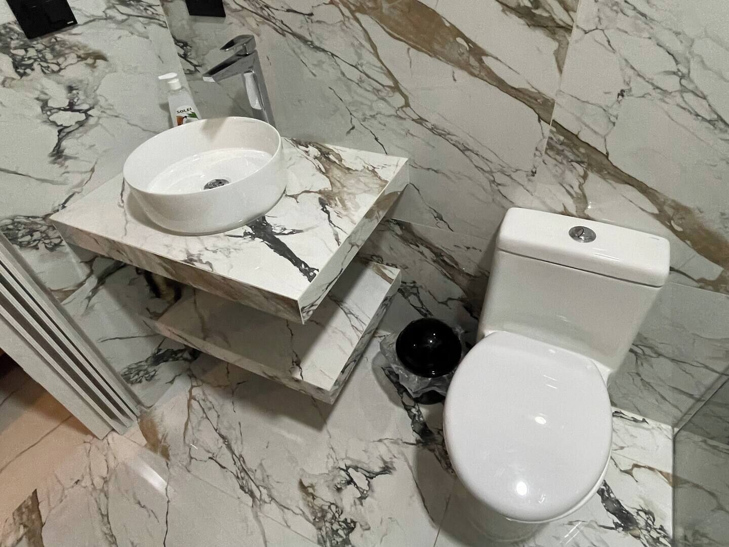 A bathroom with a marble sink and toilet.