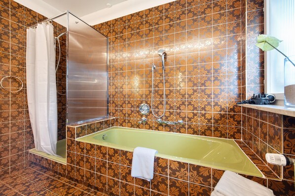 Une salle de bain avec une douche, une baignoire et des toilettes.