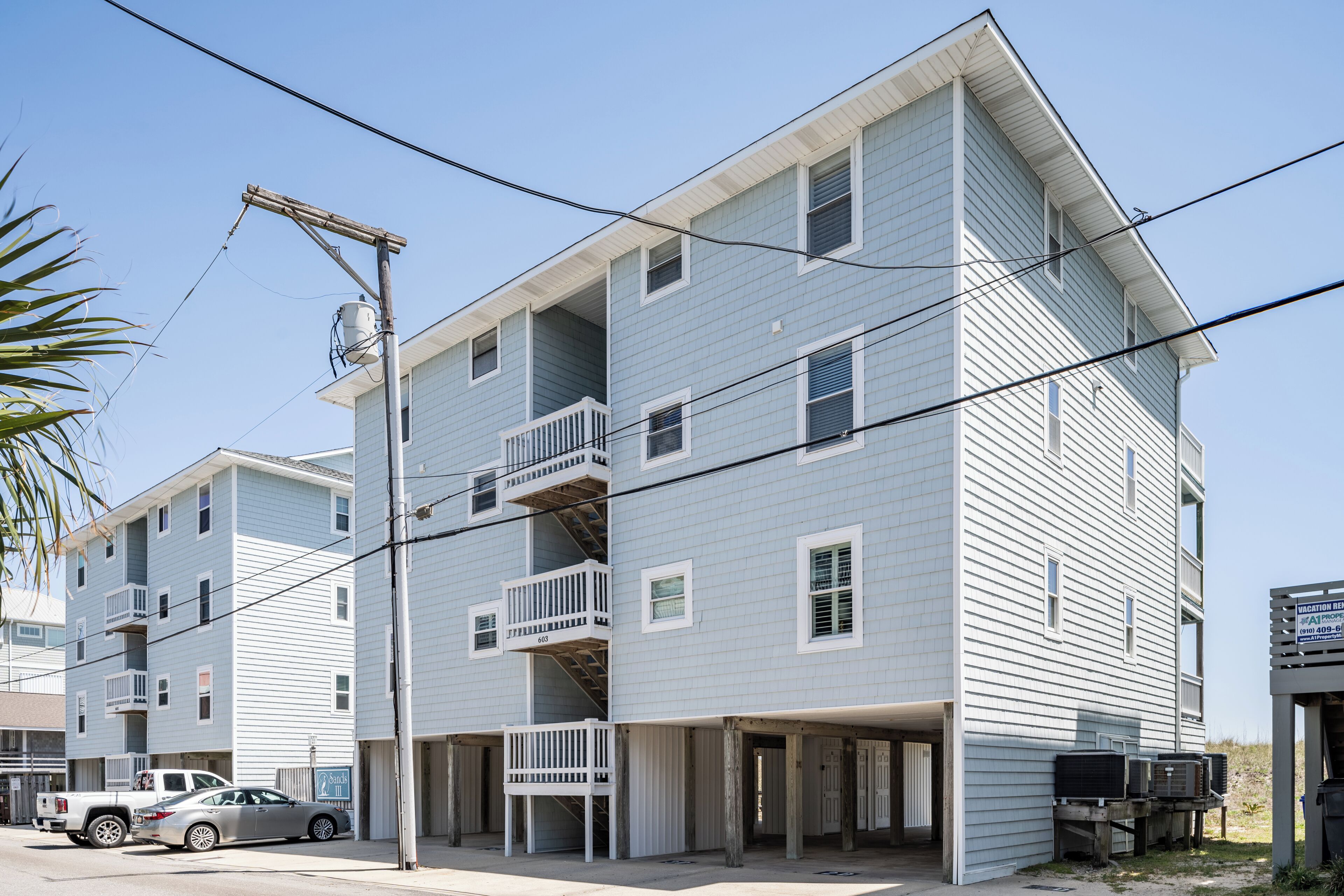 Un immeuble à plusieurs étages doté de balcons et d’un espace de stationnement.