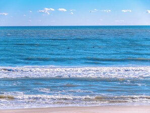 A beach with clear blue water and a sandy shore. - Pelican Nest by Topsail Realty (Sneads Ferry)